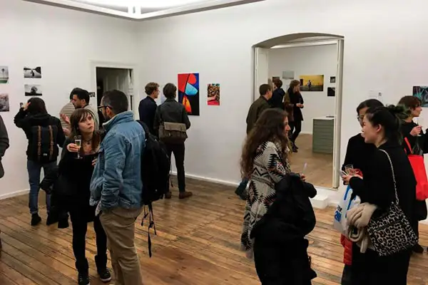 Visitors attending a photography exhibition at Eigenheim Gallery in Berlin featuring work by Federico Antonello