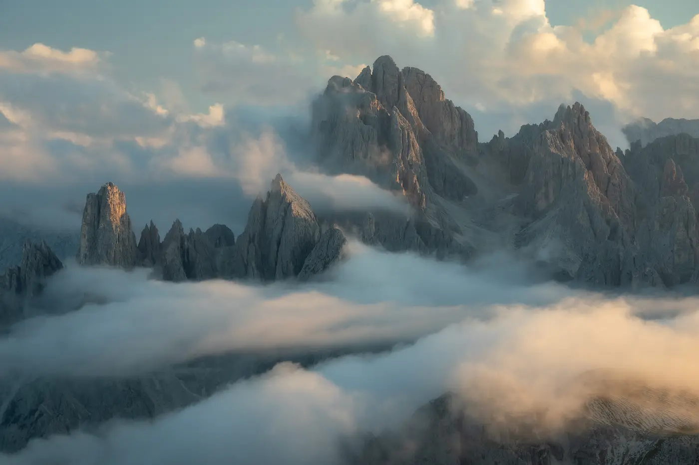 Cadini di Misurina peaks emerging through low clouds at sunrise in the Dolomites, Italy