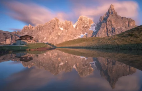 Sunset light reflecting in a mountain lake beneath the Pale di San Martino peaks in the Italian Dolomites.