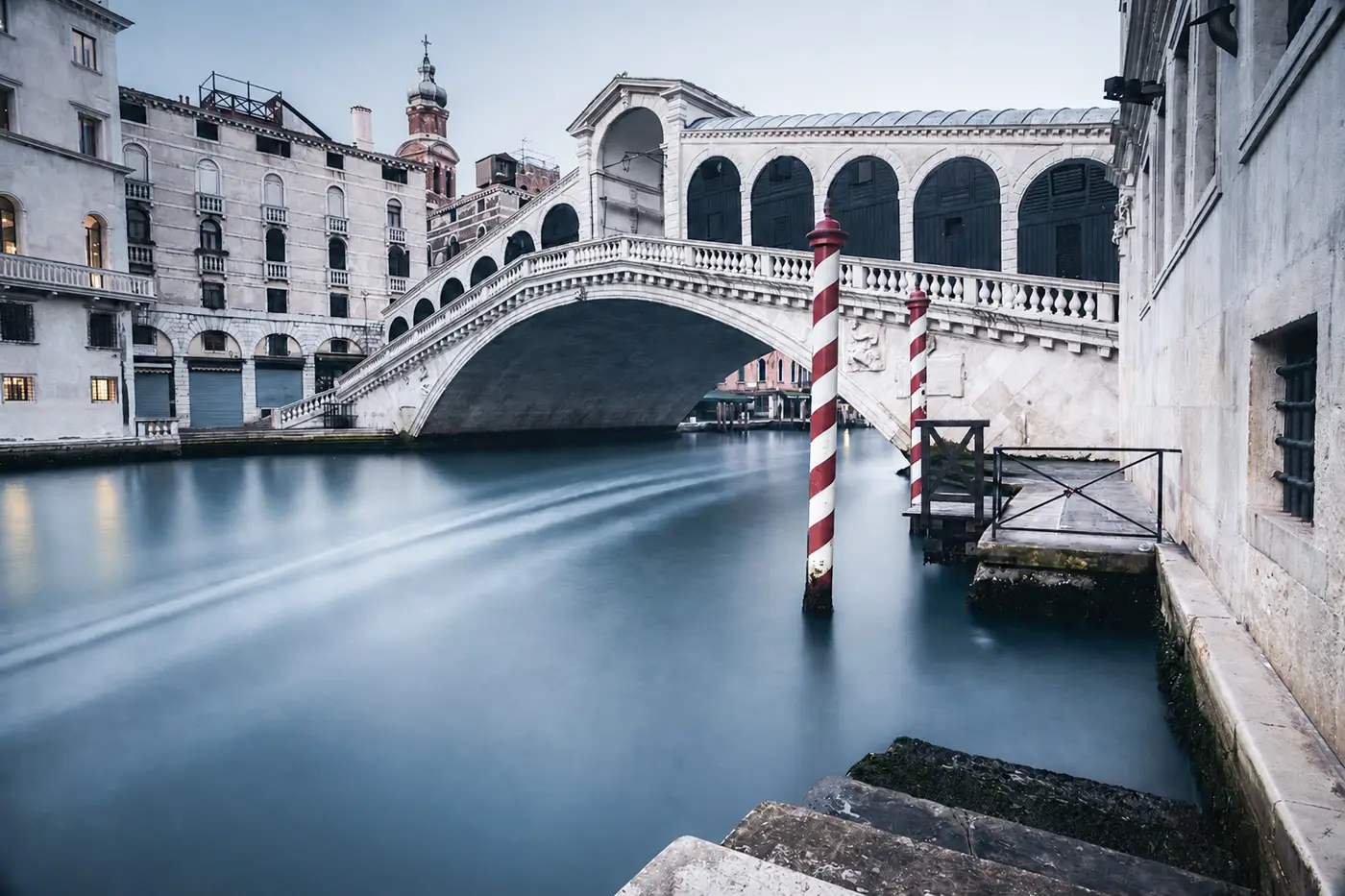Long exposure photograph of the Rialto Bridge in Venice during blue hour.