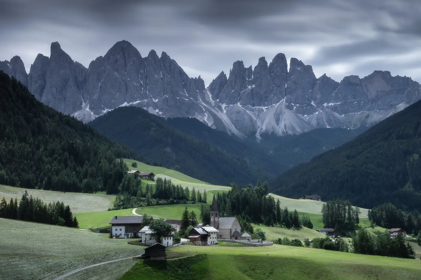 Val di Funes village with the Odle peaks rising above alpine meadows in the Dolomites, South Tyrol, Italy