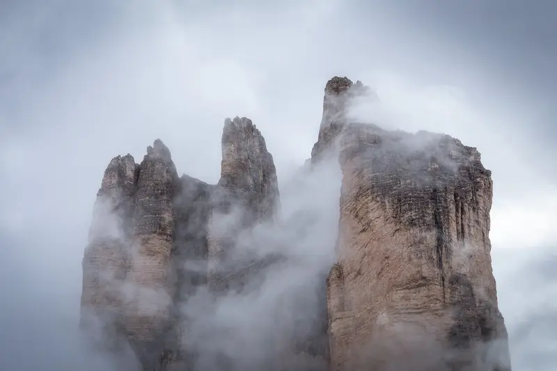 Tre Cime di Lavaredo emerging through the clouds in the Dolomites