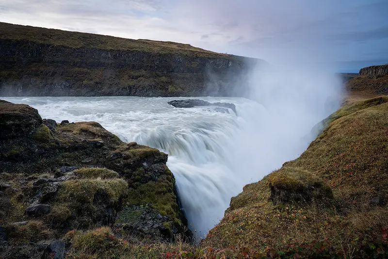 Close view of Gullfoss waterfall in Iceland, with glacial water plunging between rocky cliffs and rising mist